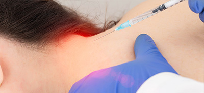 a beautician wearing gloves providing an injection for migraine prevention